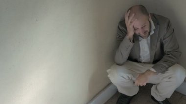 öfkeli ve sinirli bir adam yere çömelmiş