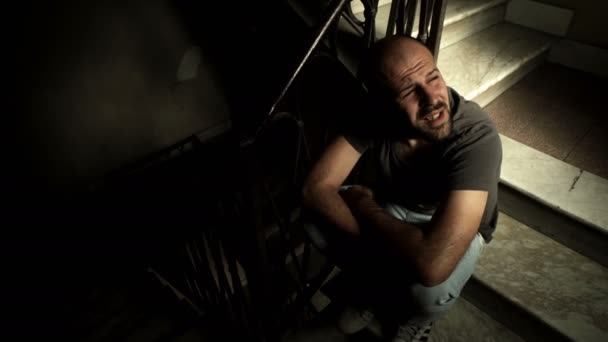 Dreißig-jähriger Mann weint auf der Treppe — Stockvideo