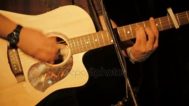 müzisyen ellerini ustalıkla bir konser sırasında acustic gitar çalış