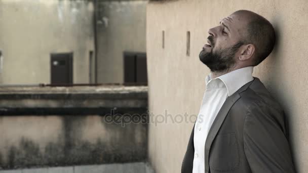 Elegante uomo calvo disperato, piangendo agaist un muro — Video Stock