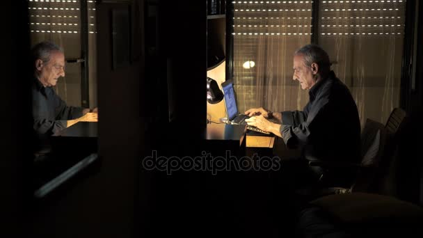 Old man typing on keyboard of laptop — Stock Video