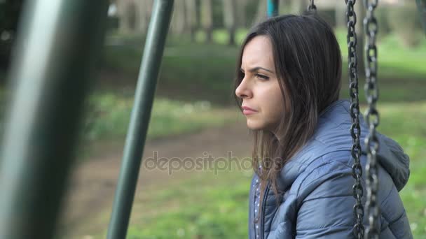 Депрессивная женщина сидит на качелях — стоковое видео