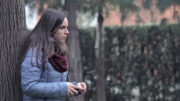年轻女人谈与耳机电话 — 图库视频影像