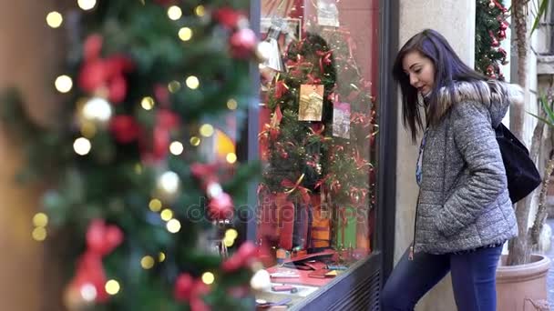 Julhandeln: ung kvinna stannar framför ett skyltfönster — Stockvideo