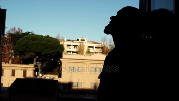 Arkadan aydınlatmalı pencerenin önünde depresif adam — Stok video