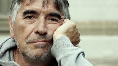 Düşünceli adam yüzünü kameraya bakarak eliyle tutarak