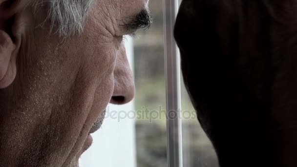 Hombre de cincuenta mira algo a la ventana — Vídeo de stock