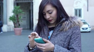  genç kadın olarak o onun smartphone (açık havada kullanır)