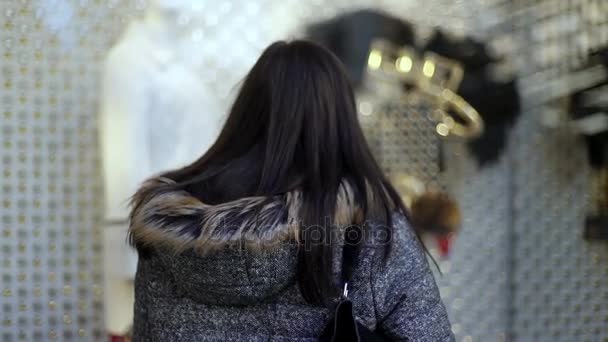Compras de Navidad: mujer joven se detiene frente a un escaparate — Vídeo de stock