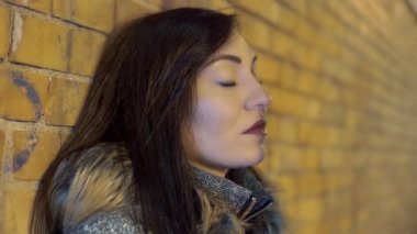 duvara yaslanmış sıkılmış genç kadın