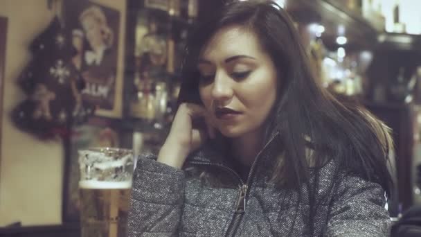 Bir barda bir bardak bira içme büyüleyici ve depresif kadın — Stok video