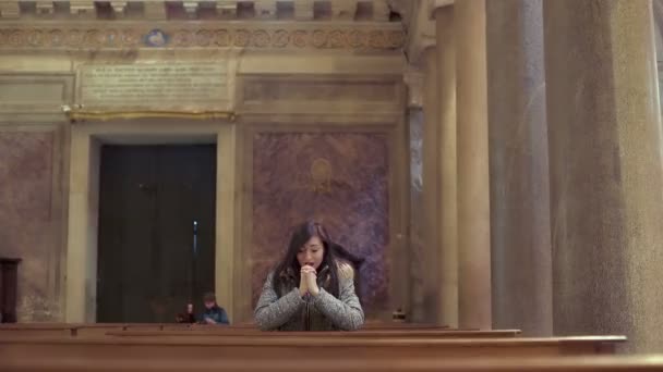 Zoufalá žena se modlí ve starověké církvi — Stock video