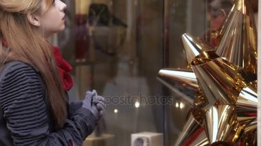 sarışın kadın Noel alışveriş sırasında bir pencere önünde durur