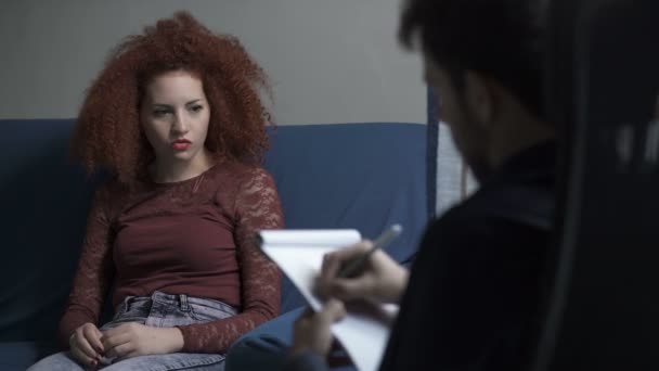 Молодая женщина разговаривает со своим психоаналитиком — стоковое видео