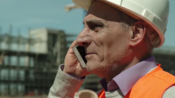 Arquiteto sênior no canteiro de obras falando ao telefone — Vídeo de Stock