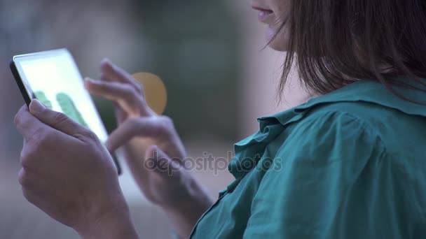 На відкритому повітрі молода жінка використовує планшет — стокове відео