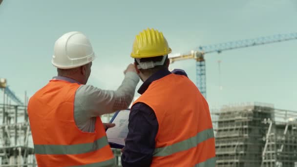 Iki mühendis inşaat sahasında yapım aşamasında kontrol — Stok video