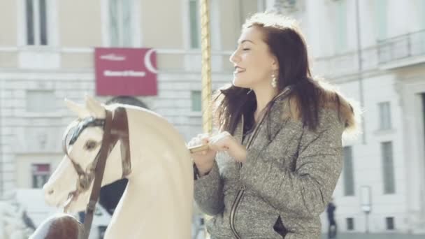 Søt og lykkelig kvinne som har det gøy på en karusell – stockvideo