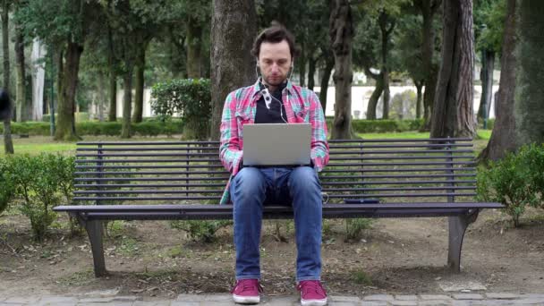 Giovane freelance nel parco con computer portatili — Video Stock