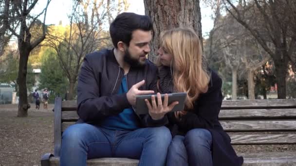 Giovane coppia al parco divertirsi con tablet — Video Stock