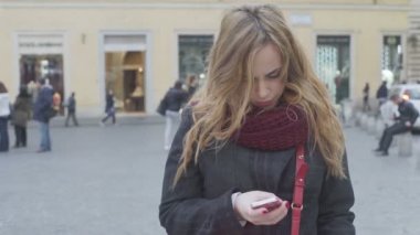 Akıllı telefon kullanan genç bir kadın.