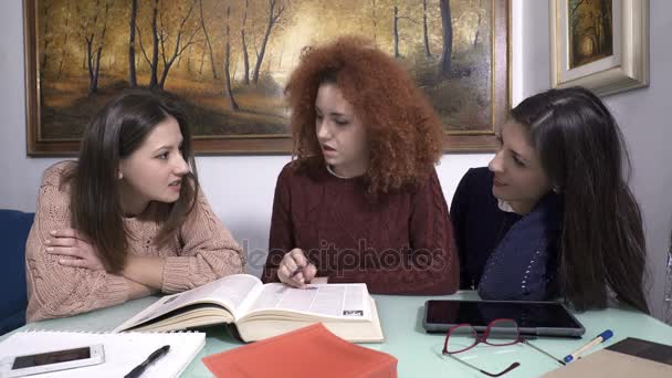Drie jonge meisjes chatten en lachen terwijl er over de les — Stockvideo