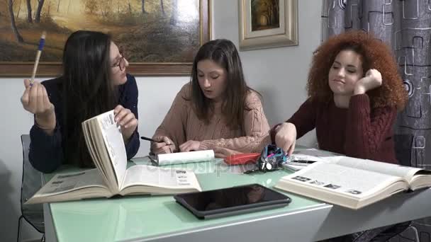 Три молоді дівчата спілкуються і сміються під час уроку — стокове відео