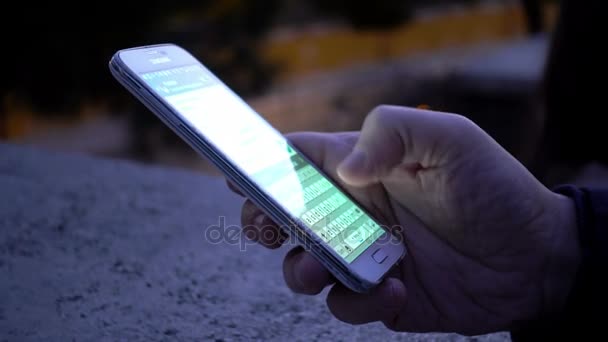 Ο άνθρωπος χέρι γράφετε μηνύματα στο smartphone στην πόλη το βράδυ — Αρχείο Βίντεο