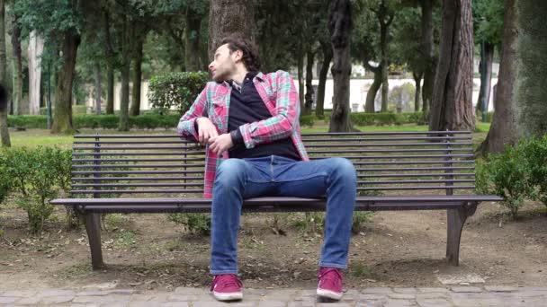 Bored man on the bench waiting for a friend — Stock Video