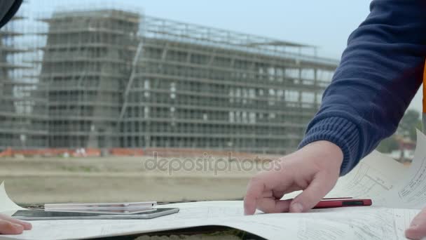 Mãos de engenheiros que indicam o projeto no canteiro de obras — Vídeo de Stock