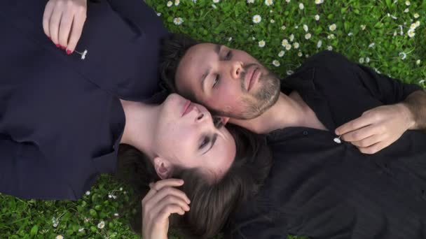 躺在草坪上，亲切地交谈，对浪漫的情侣 — 图库视频影像