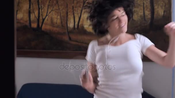 Mulher sensual dançando sozinha em casa ouvindo música com fones de ouvido — Vídeo de Stock