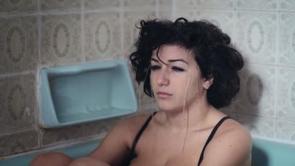 Deprimerad kvinna sitter i badkaret medan vattnet kissar håret — Stockvideo