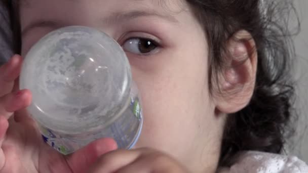 Γλυκό κορίτσι πίνει νερό από ένα μπουκάλι μωρό — Αρχείο Βίντεο