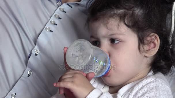 Lief klein meisje in de armen van Papa drinkt water uit een fles — Stockvideo