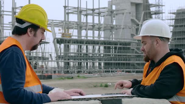 Два инженера-строителя на месте сравнения проекта — стоковое видео