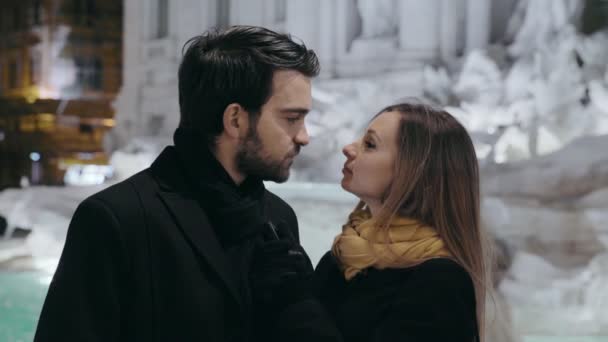 Homem e mulher flertando em uma noite de inverno com fundo fonte de Trevi — Vídeo de Stock