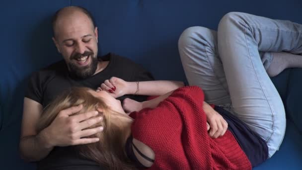 Junges Paar plaudert auf der Couch und lacht — Stockvideo