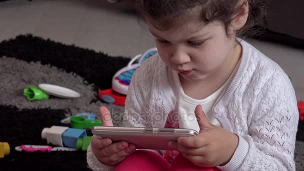Hermosa niña juega con la tableta — Vídeo de stock