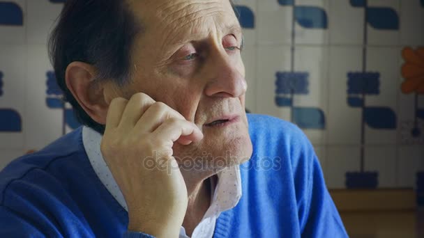 Senior blauwogige man luistert naar iemand spreken — Stockvideo