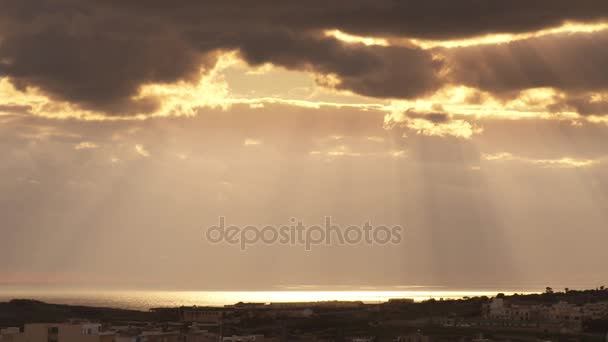 Raios de sol que saem das nuvens e iluminam o mar — Vídeo de Stock