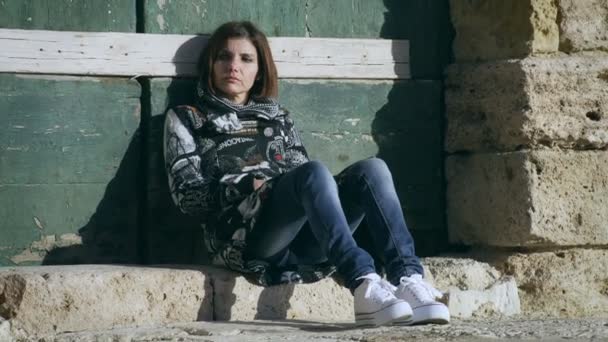 Smutny i zamyślony kobieta siedzi w słońcu — Wideo stockowe