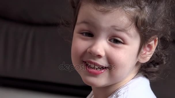 Красивая маленькая девочка улыбается перед камерой — стоковое видео