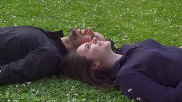 Romantisches Paar auf dem Rasen liegend und freundlich plaudernd — Stockvideo