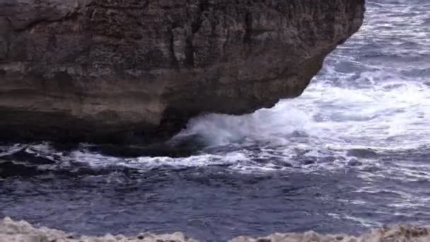 Пропонують вид на морську воду, що покриває скелі в похмурий день — стокове відео