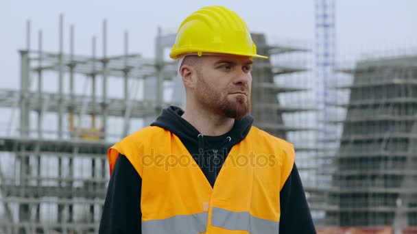 Travailleur de la construction regarde sérieusement la caméra — Video