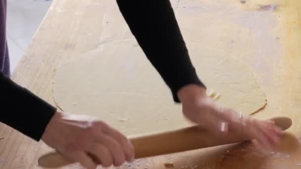 Руки женщины передают скалку на свежем тесте — стоковое видео