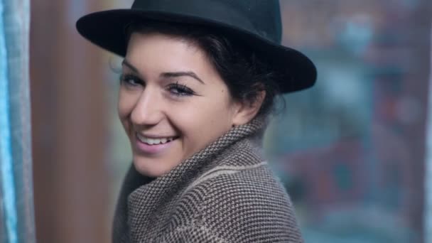 Сексуальная женщина в шляпе улыбается и флиртует с камерой — стоковое видео
