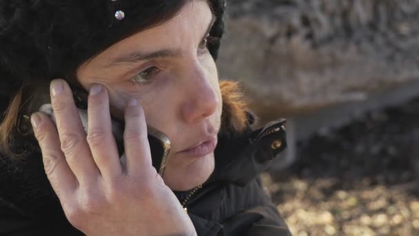 Mulher com chapéu preto falando ao telefone a sério — Vídeo de Stock