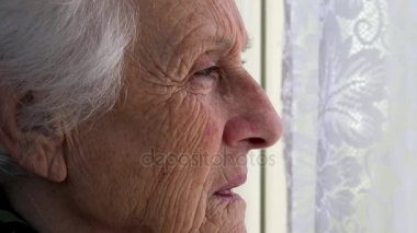 Yaşlı kadının pencereden dışarı bakarak yalnız depresif profili
